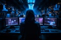 A professional hacker, hooded and enigmatic, seated in front of a bank of multiple computer screens Royalty Free Stock Photo