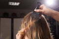 Professional haidresser brushing hair of a model close up
