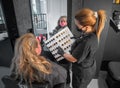 Professional hair colorist woman showing to the client colors and tones in beauty salon