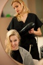 Professional hair stylist at work - hairdresser doing hairstyle Royalty Free Stock Photo