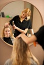 Professional hair stylist at work - hairdresser doing hairstyle Royalty Free Stock Photo