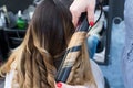 Professional hairdresser curling ombre hair with iron