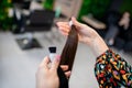 Professional hairdresser demonstrating hair samples for extension in beauty salon