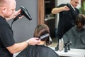 Professional hairdresser is drying female hair