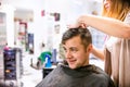 Professional hairdresser making new haircut to her handsome clie Royalty Free Stock Photo