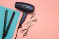 Professional hairdresser's equipment on color background. Hairdryer, scissors, and hair straightener.