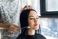 Professional hairdresser, stylist combing hair of female client in professional hair salon. Beauty and haircare concept Royalty Free Stock Photo