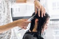 Professional hairdresser, stylist combing hair of female client in professional hair salon. Beauty and haircare concept Royalty Free Stock Photo