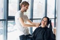 Professional hairdresser, stylist combing hair of female client in professional hair salon. Beauty and haircare concept Royalty Free Stock Photo
