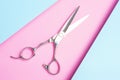 Professional hairdressing scissors close-up on blue and pink background top view. Royalty Free Stock Photo