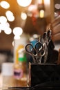 Professional hairdressing tools. Various steel scissors and combs, hairbrushes on wooden table on barbers workplace at