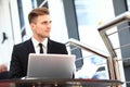 Professional handsome businessman using laptop at workplace.