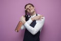 Professional handsome waiter in uniform hugs two bottles of red and white wine on a pink background, concept love of alcohol, copy Royalty Free Stock Photo