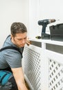 Professional handyman assembling radiator cabinet Royalty Free Stock Photo