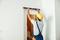 Professional handyman, male worker in uniform using spirit level while taking measurements indoors Royalty Free Stock Photo