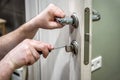 Professional handyman repair the door lock in the room, locksmith fixing lock with screwdriver