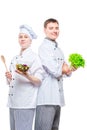 professional happy cooks in suits with salad in hands on white background