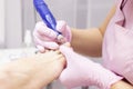 Professional hardware pedicure using an electric machine. Patient at the pedicure procedure. polishing the nail plate Royalty Free Stock Photo