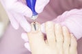 Professional hardware pedicure using an electric machine. Patient at the pedicure procedure. polishing the nail plate Royalty Free Stock Photo