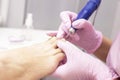 Professional hardware pedicure using an electric machine. Patient at the pedicure procedure. polishing the nail plate, processing Royalty Free Stock Photo