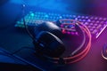 Professional headphones with microphone for video games and cyber sports gaming monitor in neon color blur background