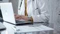 Doctor working on laptop with stethoscope on the glass desk. Medicine and Health care Royalty Free Stock Photo