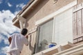 Professional House Painter Painting the Trim And Shutters of A H