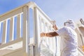 Professional House Painter Spray Painting A Deck of A Home Royalty Free Stock Photo