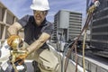 HVAC technician wearing PPE repairing air conditioner