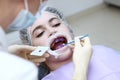 Professional hygiene of the oral cavity. The dentist applies a purple gel to the patient`s teeth before professional