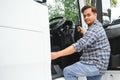 Professional indian truck driver entering his truck long vehicle. Loving his job. Transportation services