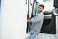 Professional indian truck driver entering his truck long vehicle. Loving his job. Transportation services. Royalty Free Stock Photo