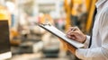 A Professional Individual Taking Notes on a Clipboard While Oversaw by Industrial Equipment in a Work Environment Royalty Free Stock Photo