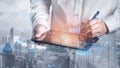 Professional Individual Using Digital Tablet for Data Analysis Overlooking City Skyline with Futuristic Graphics and Royalty Free Stock Photo