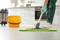 Professional janitor cleaning floor with mop in kitchen Royalty Free Stock Photo