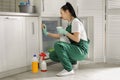 Professional janitor cleaning modern fridge