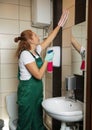 Professional janitor cleaning wall in restroom