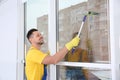 Professional janitor cleaning window with squeegee Royalty Free Stock Photo