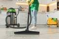 Professional janitor vacuuming floor in kitchen, closeup Royalty Free Stock Photo