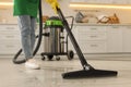 Professional janitor vacuuming floor in kitchen, closeup Royalty Free Stock Photo