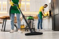 Professional janitor vacuuming floor in kitchen, closeup Royalty Free Stock Photo