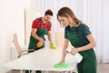 Professional janitors cleaning table in office Royalty Free Stock Photo