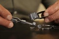 Professional jeweler working with beautiful ring at table