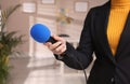 Professional journalist with modern microphone in room Royalty Free Stock Photo