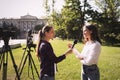 Professional journalist taking interview in front of video cameras Royalty Free Stock Photo