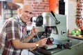 Professional key cutter making door keys copies in locksmith Royalty Free Stock Photo