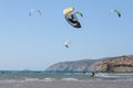 Professional kite surfer rides on a board with a plank on a lake with sea water at sunset. Water splashes and sun glare Royalty Free Stock Photo