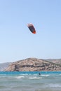 Professional kite surfer rides on a board with a plank on a lake with sea water at sunset. Water splashes and sun glare Royalty Free Stock Photo