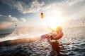 Professional kite surfer woman rides on a board with a plank in her hands on a leman lake with sea water at sunset Royalty Free Stock Photo