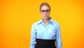 Professional lady boss looking camera on orange background, confident worker